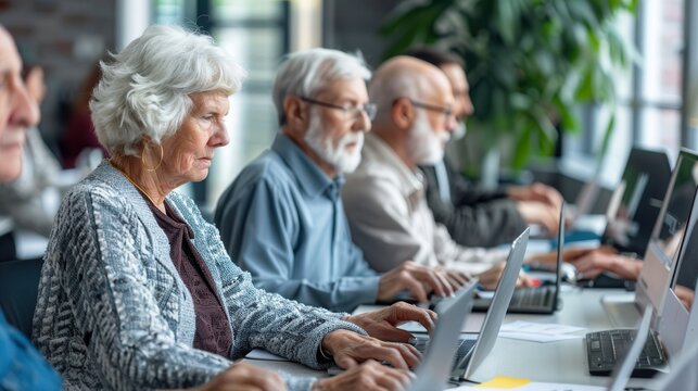 A group of elderly individuals focuses on their laptops, learning computer skills in a community center setting. Generative AI