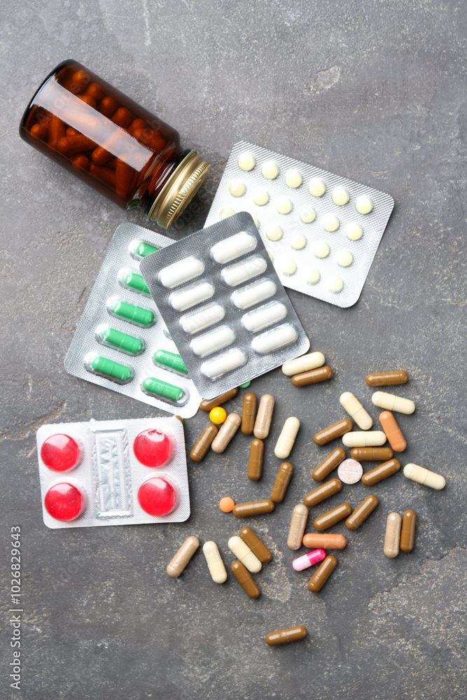 Sticker Pharmacist. Different pills and plastic bottle on grey table, flat lay