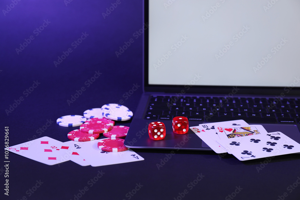 Wall mural online poker. playing cards, chips, dice and laptop on dark table, closeup