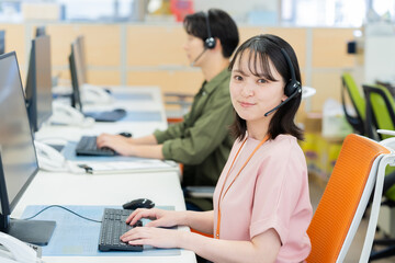 インカムで話すオペレーターの若い女性