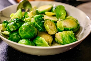 Steamed Brussels Sprouts in a White Bowl. A close-up of vibrant green steamed Brussels sprouts, served in a white bowl. 