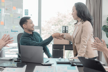Businessmen shake hands while negotiating a business deal. Repository for disputes and mediation Teamwork on business strategy The meeting discussed performance charts and graphs.