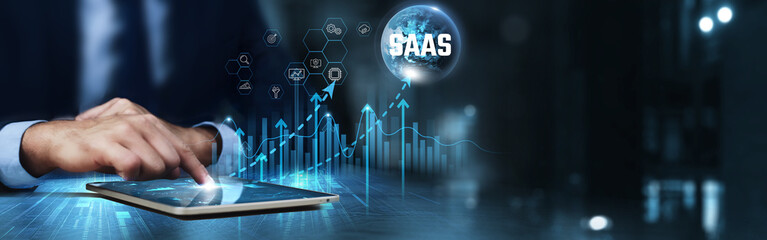 SaaS (Software as a Service): Businessman using tablet and analyzing technical growth by cloud solutions, subscription models, scalability, collaboration tools, data analytics, cost efficiency.