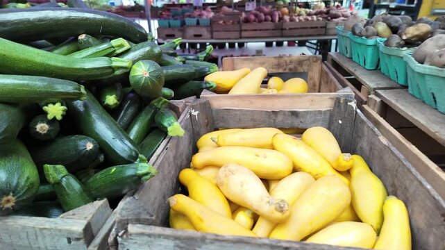 A closeup image of a pile of fresh green zucchini vegetables, showcasing their vibrant green color, smooth skin, and slightly curved shapes. The vegetables are stacked neatly, suggesting a bountiful h