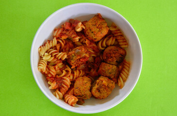 Italian style meatballs with pasta, tomato sauce and cheese in a bowl.