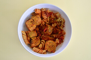 Italian style meatballs with pasta, tomato sauce and cheese in a bowl.