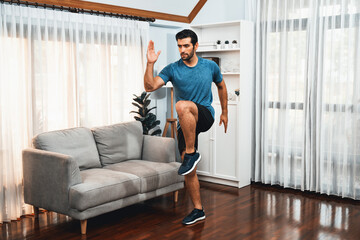 Athletic and sporty man running posture at home body workout exercise session for fit physique and healthy sport lifestyle at home. Gaiety home exercise workout training.