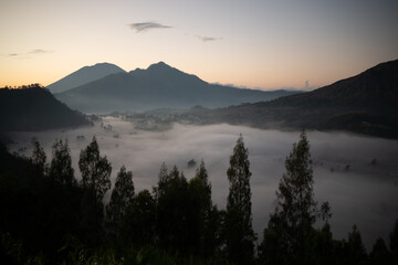 A serene sunrise scene with majestic mountains and misty valleys creates a breathtaking vista
