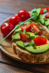 Avocado toast topped with tomato and green onion on a slice of carrot bread