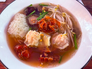 wonton soup with mushrooms, char siu, bean sprouts, chives, and a little chili paste on top, rich broth