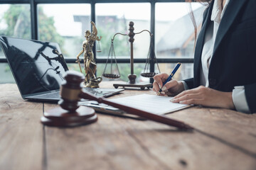 Lawyer Working on Legal Documents: A female lawyer diligently works at her desk, surrounded by...