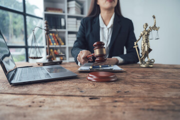 Female Lawyer at Work: A confident female lawyer sits at her desk, holding a judge's gavel, symbolizing justice and legal expertise.  The image conveys professionalism, authority.