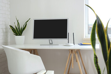 Workplace with blank computer and wi-fi router in office