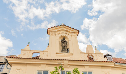 Obraz premium Religious statue on facade of house on Vltava river embankment in Prague in Czech Republic