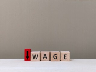 wooden cube with the word Wage and downward arrow. reduction of salary or deduction concept. business finance