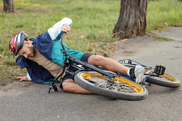 Young man fallen off his bike outdoors