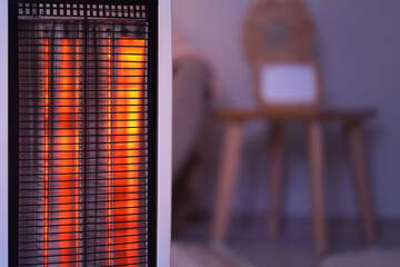 Modern electric heater in room at evening, closeup