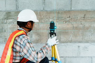 Construction Worker Using Laser Level Tool for Measurement