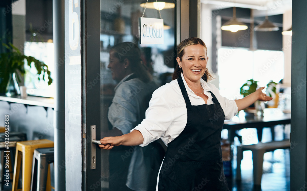 Wall mural Happy woman, portrait and welcome with open door at cafe or ready for service at restaurant. Young, female person or waitress with smile for hospitality, introduction or arrangement at coffee shop