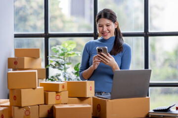 Entrepreneurs small business SME independent asian woman work at home use calculator on phone and...