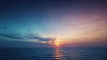 A breathtaking view of mountain ranges at sunset, with layers of blue hues and a warm orange sky. Silhouettes of mountains against a vibrant sunset sky