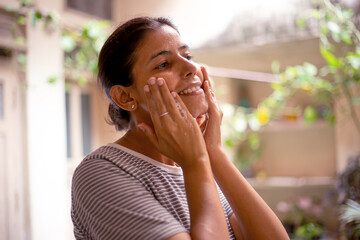 An Indian woman doing her skincare