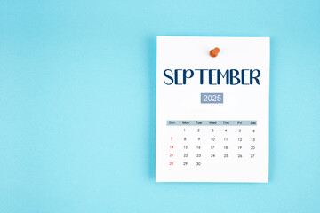 September 2025 calendar page with push pin on blue background.