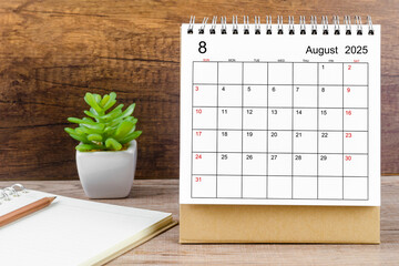 August 2025 desk calendar on table.