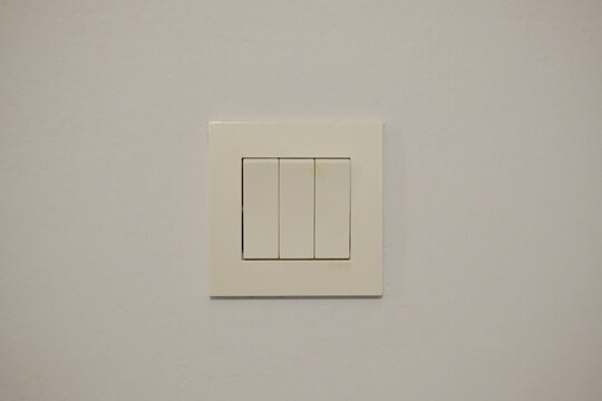 A plain light switch on a white wall.
