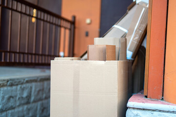cardboard boxes and recyclable paper neatly arranged at a designated collection point outside a residential building, promoting sustainable waste management practices