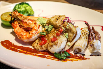 Gourmet seafood plate with prawns, fish, and squid