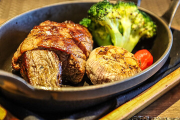 Grilled steak with roasted garlic and broccoli in a cast iron skillet