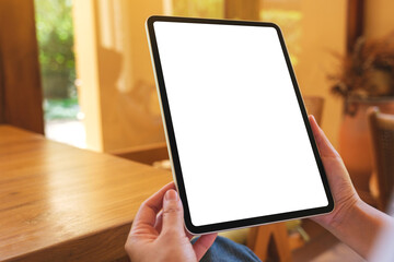 Mockup image of a woman holding digital tablet with blank desktop screen at home