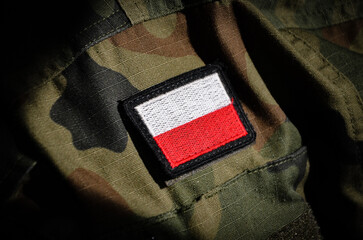 White and red flag of Polish on a camo military uniform