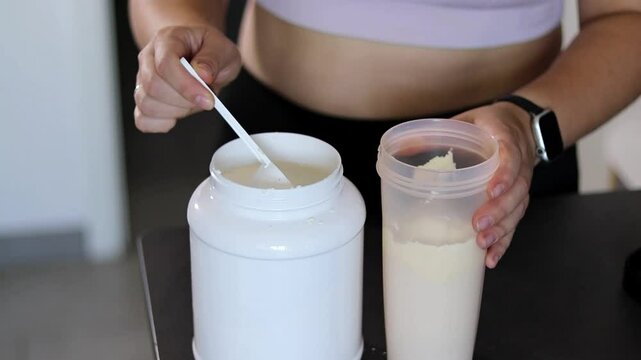Close up of woman preparing a protein shake in the kitchen. Diet meal replacement for weight loss 