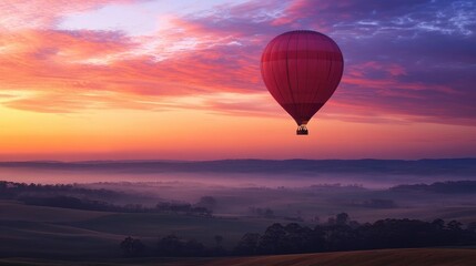 Obraz premium A balloon floating in a pastel sky at dawn, with scenic rural landscapes below. No people.