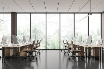 Stylish workplace interior with desk and pc computers in row, panoramic window