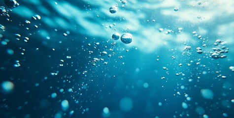 Close-up of bubbles rising in clear blue water.