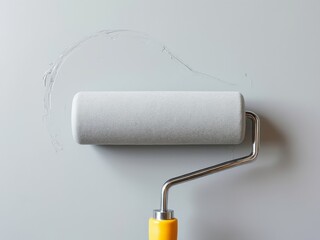 Obraz premium Gray paint roller applying fresh light gray paint on wall, capturing the painting process with smooth, wet strokes and minimalistic background