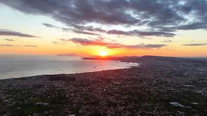 A breathtaking aerial view of Ercolano,with the city nestled between the sea and the mountains.Drone captures the stunning coastal panorama,showcasing the ancient ruins and the shimmering waters below