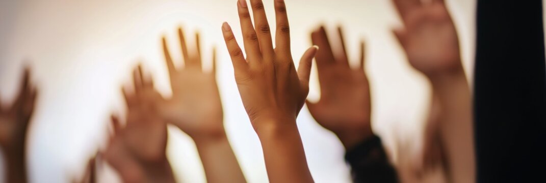 A crowd of various hands raised, representing eagerness, participation, and collective action, emphasized through bright, warm lighting.