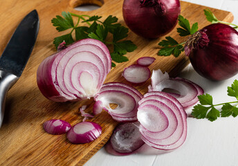 Chopped red onion and sprigs of parsley on a cutting board
