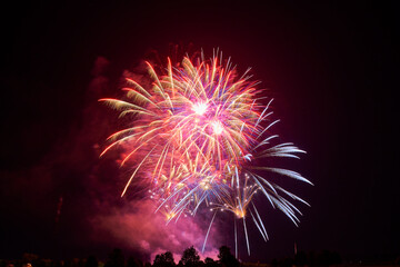 A vibrant fireworks display against a night sky, bursting with colors and light, creating a spectacular visual effect and capturing the excitement of the celebration.