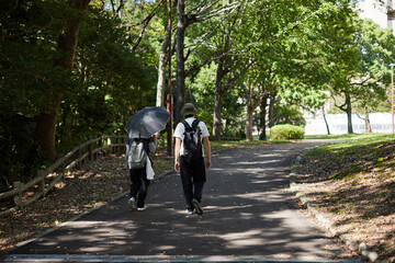 秋の公園で散歩する男女の姿