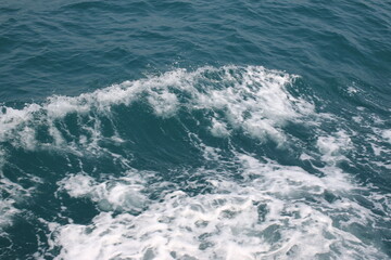 Turquoise ocean sea water white wave splashing deep blue sea. Bird eye view monster wave splash on rock. Tropical sea beach in summer seaside outdoor. Ocean island beautiful dramatic landscape.