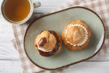 Religieuse French choux bun patisserie classic, filled with fluffy vanilla cream closeup on the...