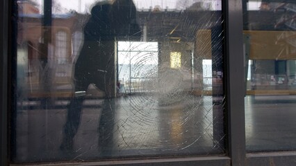 Reflections in a shop window cracked by a violent impact photographed from the street.