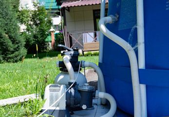 Close-up of a pool filtration system in a backyard garden.