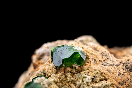 Demantoid, green andradite garnet. Specimen from Takab, West Azerbaijan, Iran. macro photography detail texture background. close-up mineral crystal unpolished semi-precious gemstone
