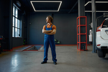 Full length portrait of man auto mechanic wearing uniform over garage interior